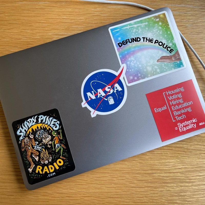 These are the stickers on my personal laptop so far. I like stickers. On this laptop I’ve decided there won’t be any tech companies or technologies. What else should I add?