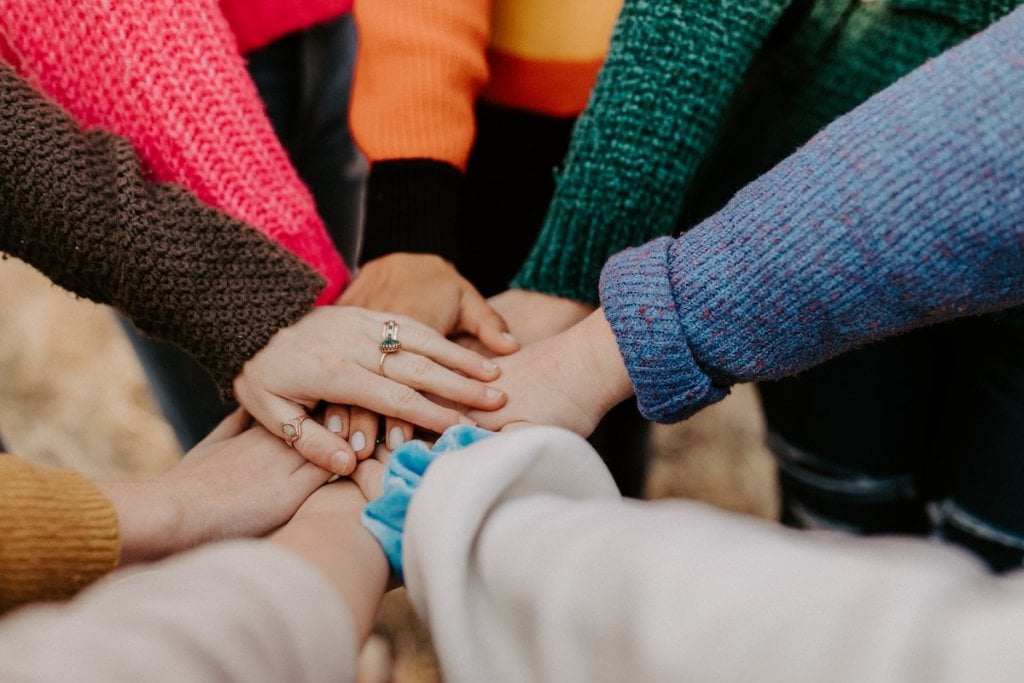 A photo of lots of different people joining hands