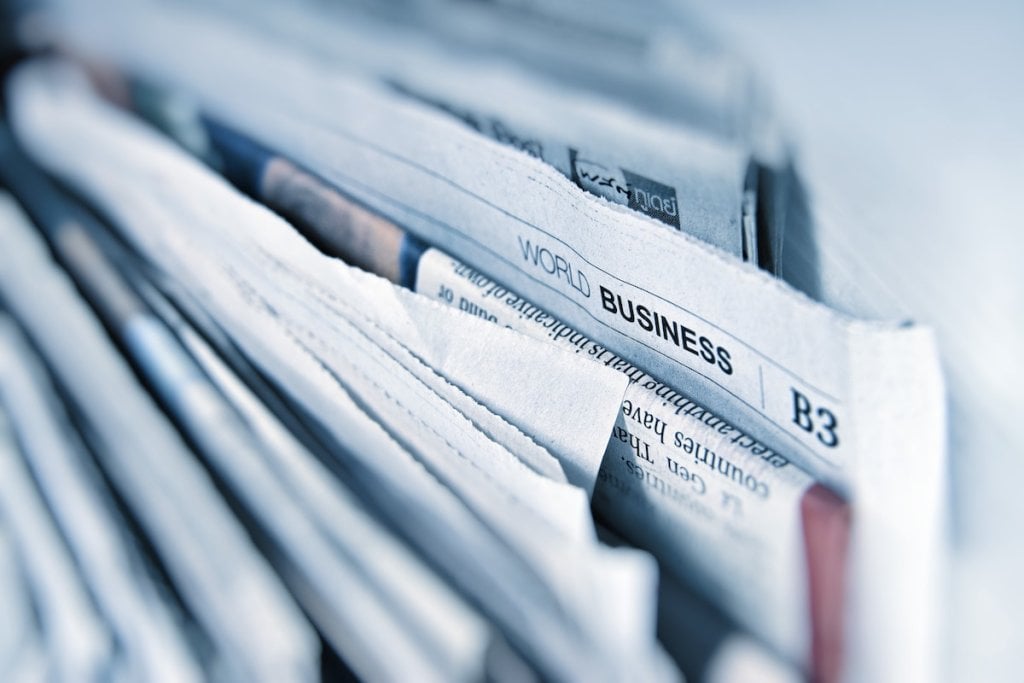 A pile of newspapers showing a business section exposed