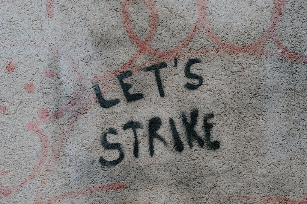 Graffiti on a wall that reads: let's strike