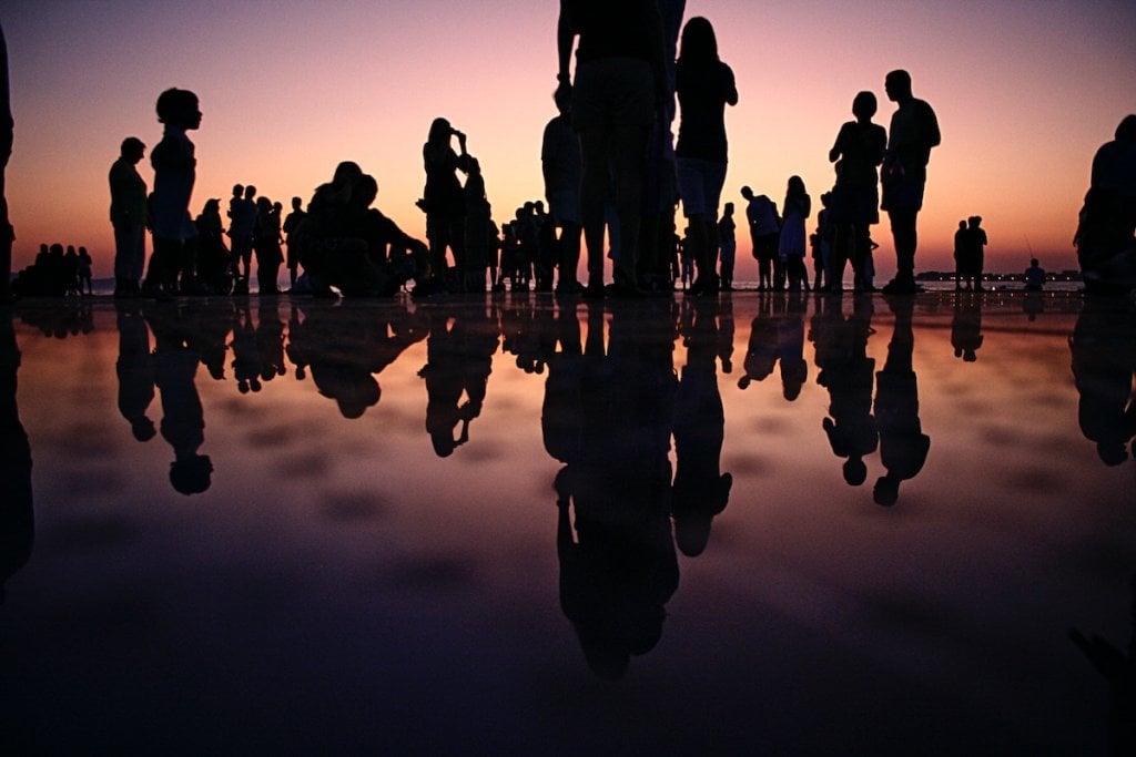 Silhouettes of people gathering at sunset