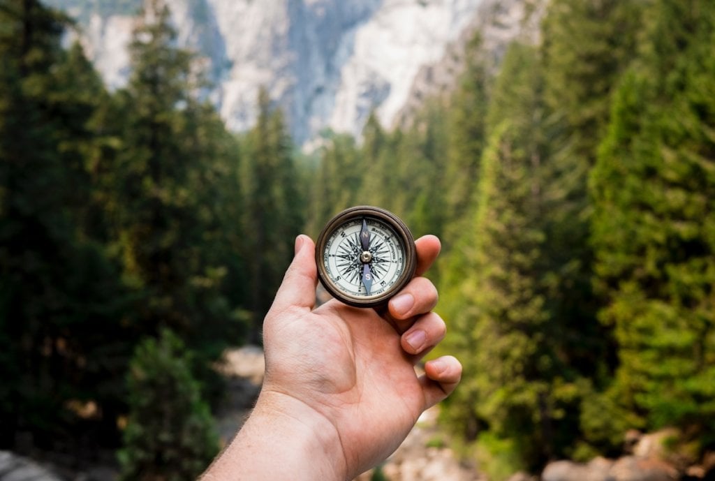 Someone holding up an old-fashioned compass in Yosemite