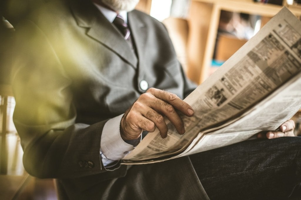A senior man reading a newspaper