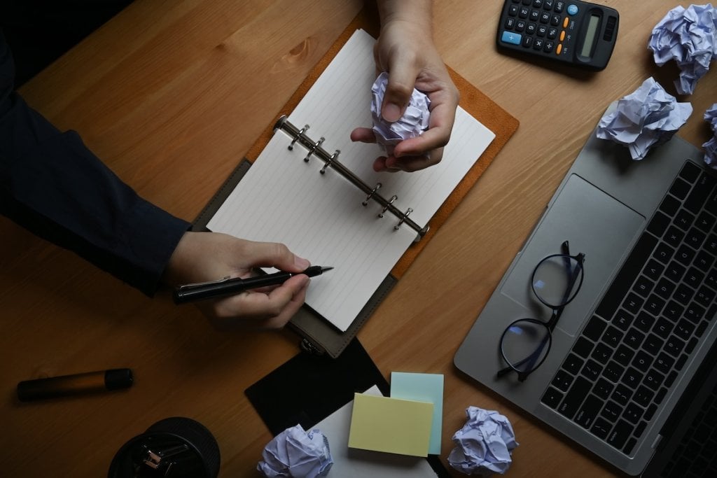 A knowledge worker, seen from above, reflecting in a journal