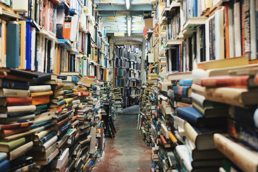 A lot of books, piled up in the best kind of bookstore